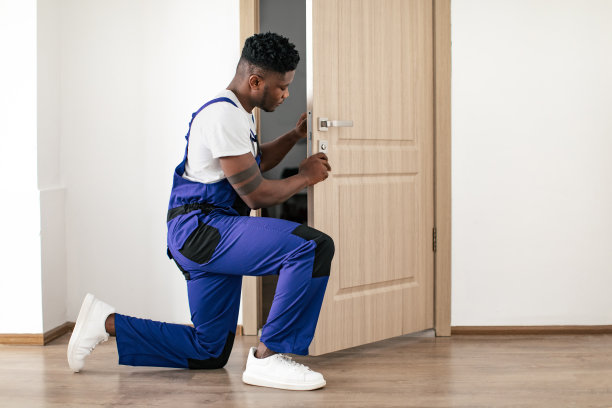 非裔美国男性工人在公寓室内安装新门图片下载