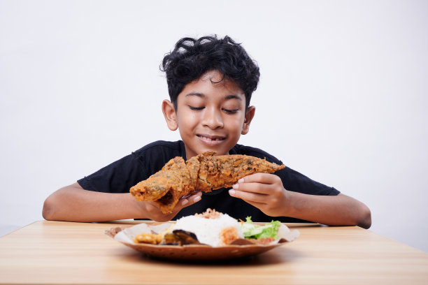 男孩喜欢在午餐时间吃炸鱼和米饭图片下载