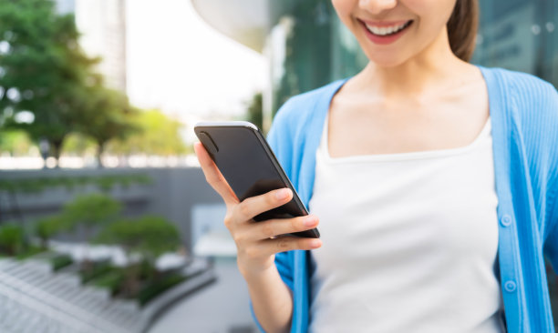 女性在公共场所和休闲时间使用智能手机。使用手机的概念在日常生活中是必不可少的。图片下载