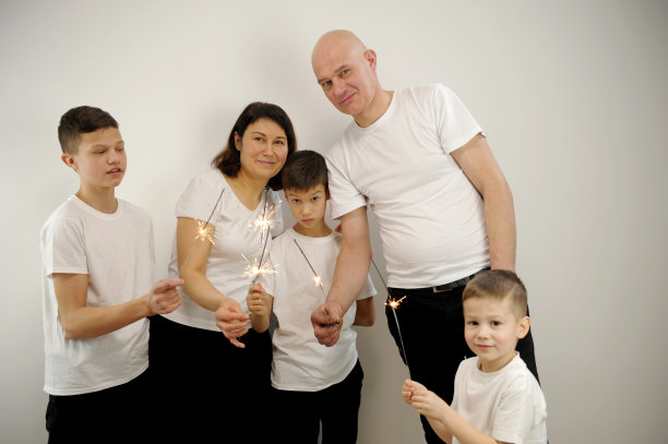 人们在家里玩烟花，一起庆祝他们的孩子生日，快乐和微笑。图片下载