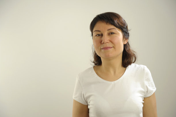 亚洲女性的形象，公司员工戴着眼镜，微笑着拿着平板电脑，站在白色背景上图片下载