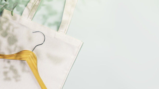 木制衣架上纺织购物袋在蓝色背景与复制空间图片下载