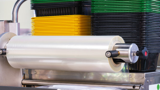 带照明效果的全自动聚乙烯塑料袋生产机。浅蓝色场景中塑料袋生产机滚筒的特写。产品包装概念图片下载