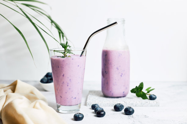 桌上有杯蓝莓奶昔。理想的素食早餐，饮食和排毒图片下载