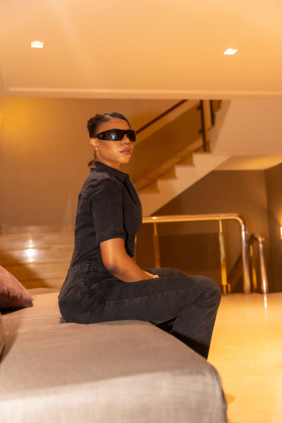 黑人民族妇女戴着墨镜坐在酒店的沙发上，奢华的概念，生活方式图片下载