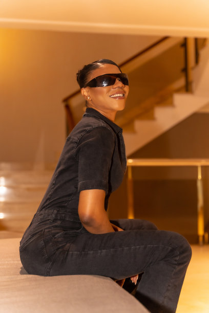黑人民族妇女戴着墨镜坐在酒店的沙发上，奢华的概念，生活方式图片下载