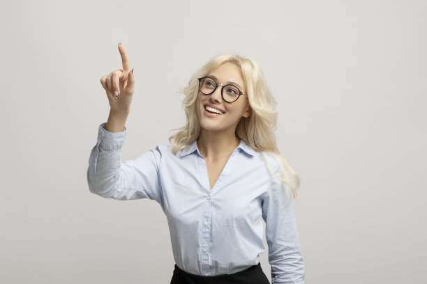 快乐的女企业家在浅灰色工作室背景的虚拟屏幕上按按钮，为设计的模型图片下载