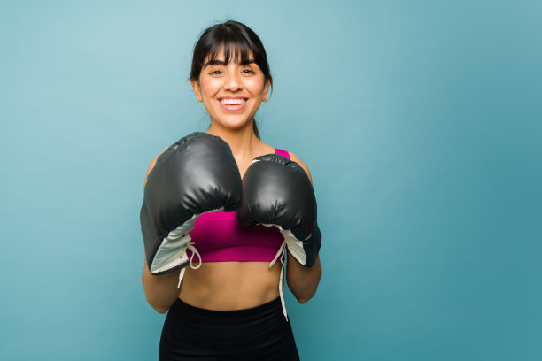 快乐的运动妇女与拳击手套准备战斗图片下载