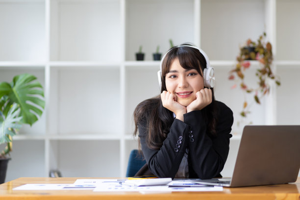 年轻迷人的亚洲商业女性在休息时间听音乐和玩的放松工作。图片下载