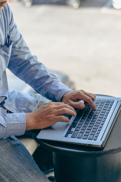 年轻的当代办公室经理在工作时手按笔记本电脑键盘成功的男性程序员工作软件程序垂直图像图片下载