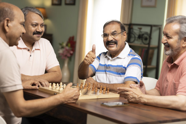 一位老人竖起大拇指，而他的朋友坐在他旁边。库存图片图片下载