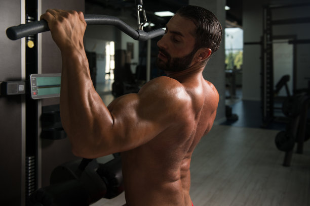强壮的肌肉男在有线机锻炼背部图片下载