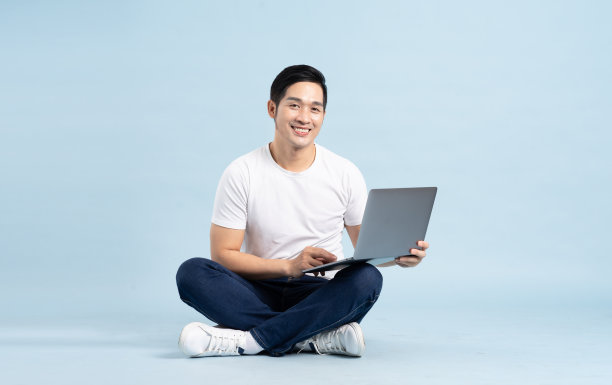 亚洲男子在蓝色背景上摆姿势的肖像图片下载