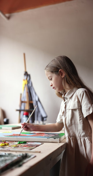 美丽的小女孩独自站在画室画画图片下载