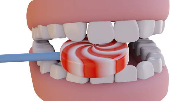 白色背景上，牙齿之间有白色和红色条纹的棒棒糖。牙医和牙齿健康概念图片下载