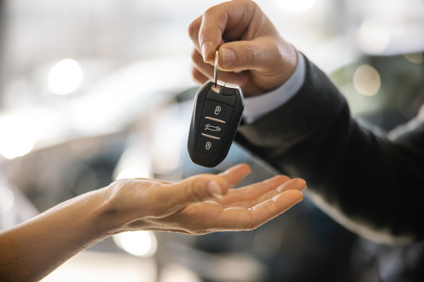 一名身着西装的男车商成功付款后，一名女顾客接过她的新车钥匙图片下载