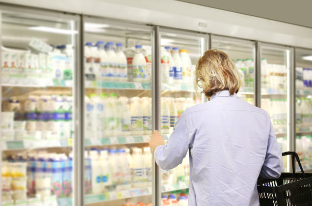 男人从超市冰柜选择冷冻食品并阅读产品信息图片下载