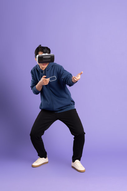 亚洲男子在紫色背景上戴虚拟现实眼镜的图像图片下载