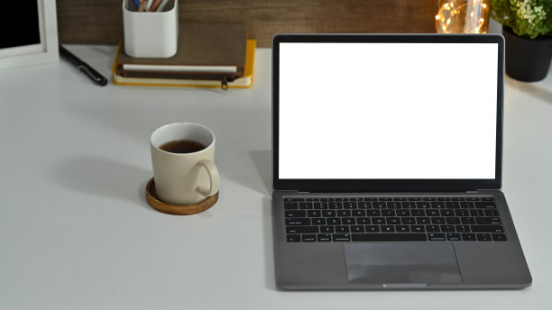 模拟笔记本电脑，咖啡杯和白色办公桌上的用品。空白屏幕为您的广告文本。图片下载