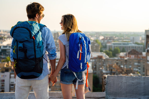 年轻的游客夫妇背着背包一起在暑假游览城市的肖像。图片下载