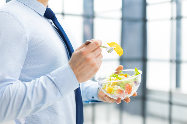 不知名的商人午餐吃蔬菜沙拉，健康和生活理念。图片下载