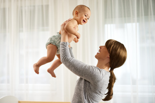 美丽的年轻母亲与她的男婴玩耍的肖像图片下载