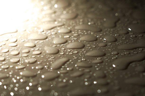 水滴落在瓷砖地板上。地面上水滴的特写照片图片下载