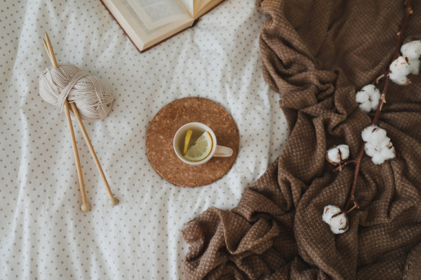 舒适的静物室内细节与一本书，茶杯和针织针在温暖柔软的床上。甜蜜的家图片下载