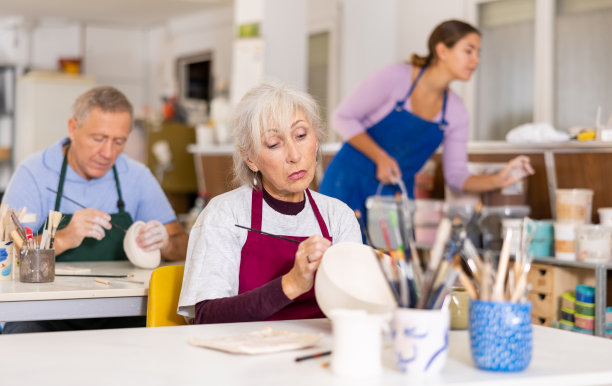成熟的女人在艺术工作室画陶土图片下载