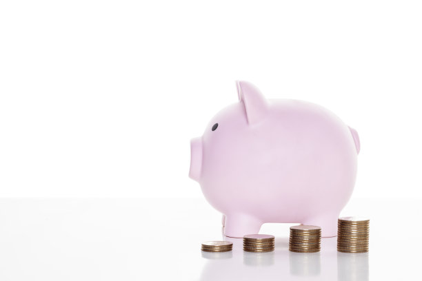 粉红色的存钱罐和一堆硬币在桌子上孤立的白色背景与修剪路径。业务。金融图片下载