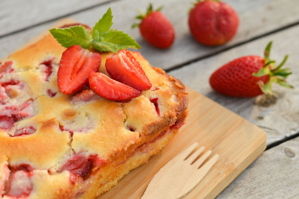 美味的夏日甜点草莓派，自制的薄荷叶装饰的节日蛋糕放在轻木桌上。图片下载