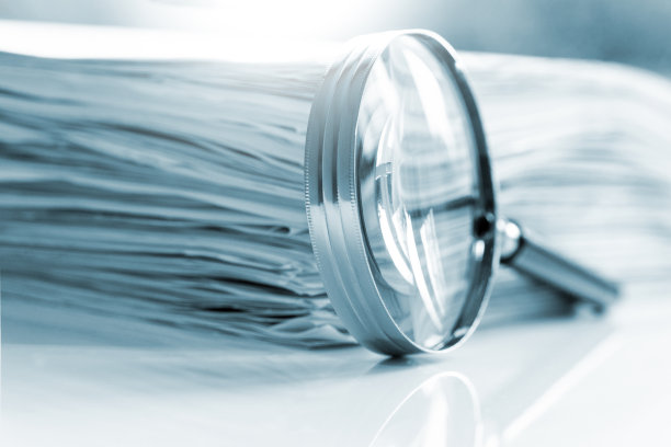 放大镜放在一堆文件前图片下载