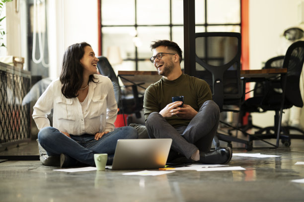 女商人和商人坐在地板上。参与项目的同事图片下载