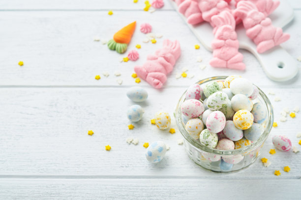 甜蜜的复活节概念。甜蜜的复活节孩子节日品种棉花糖兔子，巧克力复活节蛋，糖果，兔子，零食在白色的木制背景。平铺复活节的装饰思路。模拟。图片下载