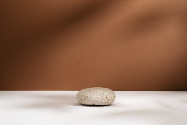 空石讲台与灯光和阴影的棕色背景。最小的背景。圆形天然岩石用于化妆品广告。展示座用于展示的底座或陈列柜侘寂概念图片下载