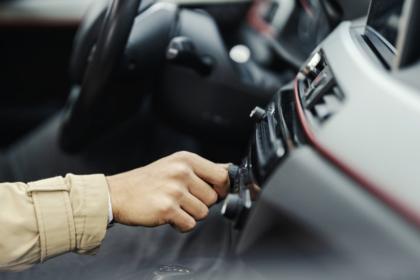 一个手的特写打开了汽车里的音乐。图片下载