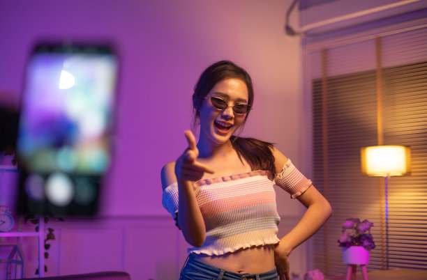 亚洲年轻美丽的女人streamer听音乐跳舞和听音乐在家庭内部，住宅楼。图片下载