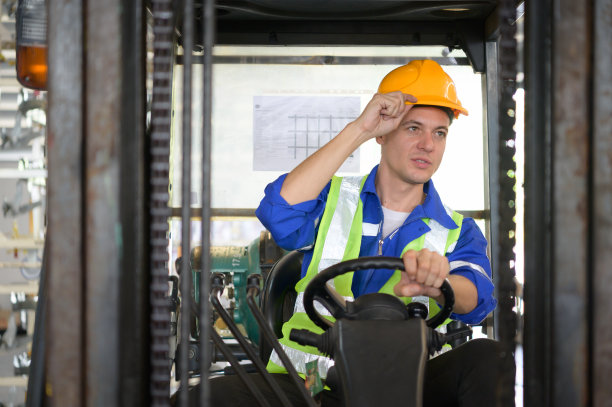 汽车配件库的工人使用叉车工作，将汽车配件箱搬运到仓库的仓储货架上，等待运送到汽车装配线图片下载