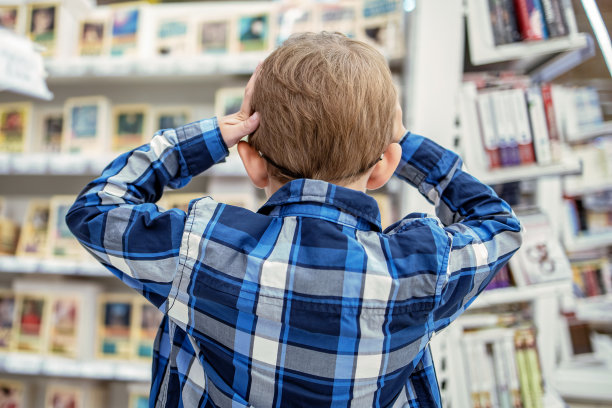 孩子在书店里抱着他的头，因为有很多选择——需要阅读图片下载