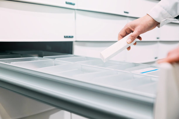 药师从抽屉拿药的特写镜头图片下载