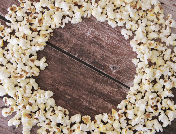 白色的炸爆米花放在棕色的木头背景上图片下载