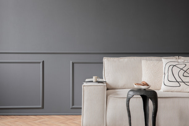 极简主义构图的客厅内部与模拟海报框架，复制空间，模块化沙发，木制咖啡桌，地毯，深色墙壁与灰泥和个人配件。家居装饰。模板。图片下载