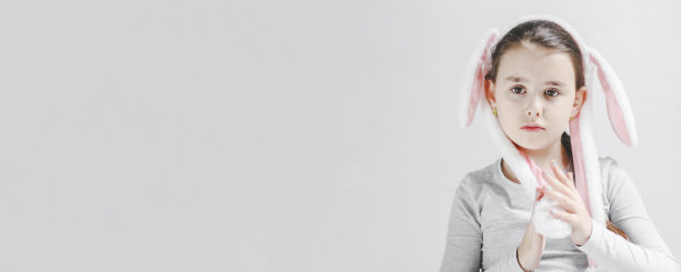 美丽的白人女孩，脸上带着微笑，戴着流行的复活节兔子头带，耳朵在动图片下载