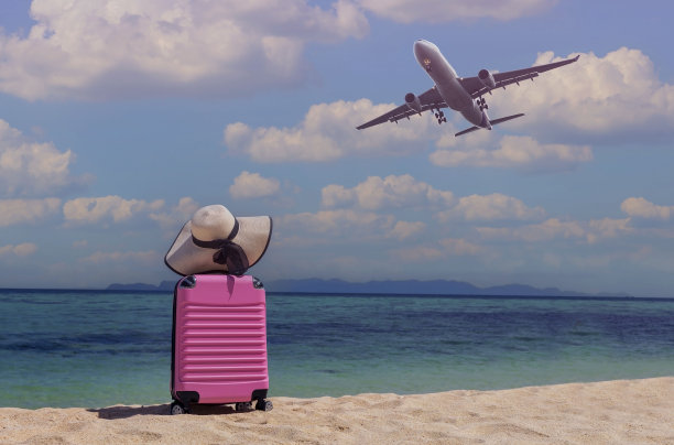 旅游概念与粉色行李箱旅行箱暑假概念，在海滩上旅行和享受图片下载
