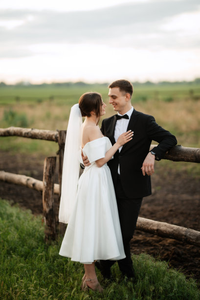 年轻的新人新郎穿黑色西装，新娘穿白色短裙图片下载