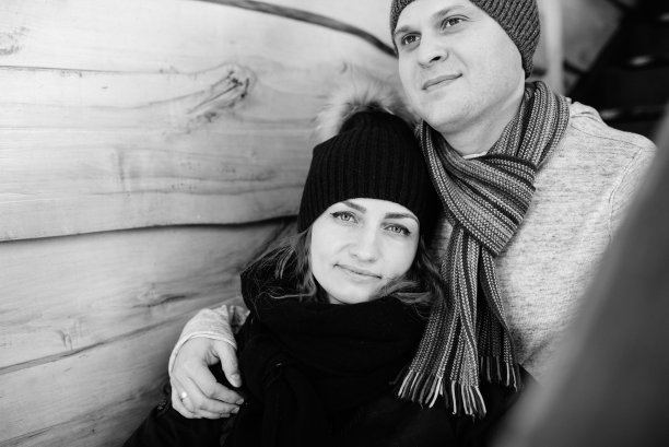 一对年轻人在白雪覆盖的木屋门廊上图片下载