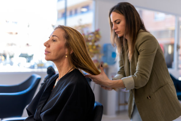女发型师在沙龙检查客户的头发图片下载