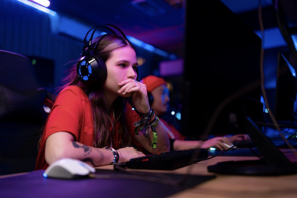深思熟虑的女玩家在游戏俱乐部玩电子竞技。图片下载
