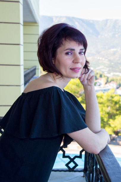 一名年轻女子从她家的阳台上看着这座城市图片下载