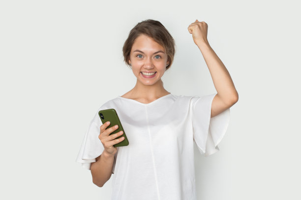 快乐兴奋快乐的女人拿着手机喊着说好的，好消息，庆祝成功，获胜图片下载